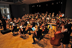 Ein Archivbild einer früheren Probe des Jugendsinfonieorchester, zu sehen sind viele junge Menschen, die musizieren 